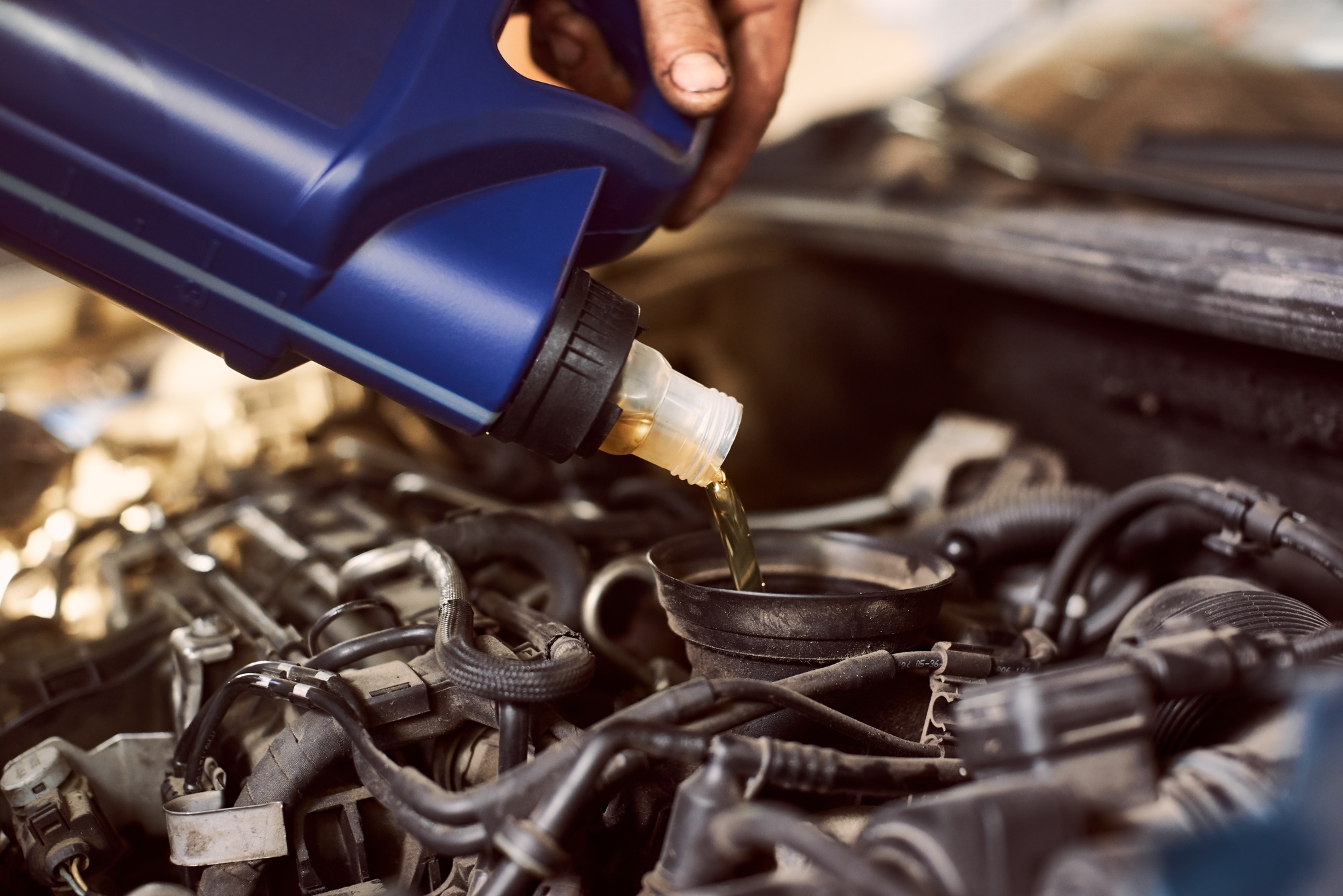 Engine oil changing and maintenance gear car engine in auto service workshop.